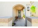 Charming covered front porch featuring an arched entrance, stylish exterior lighting, and space for seating at 6425 Classic Ridge St, North Las Vegas, NV 89086