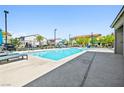 Community pool with clear blue water, lounge chairs, and well-maintained surroundings for residents to relax and enjoy at 6425 Classic Ridge St, North Las Vegas, NV 89086