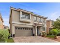Two-story home with desert landscaping and a brick driveway and walkway at 6540 W Cougar Ave, Las Vegas, NV 89139