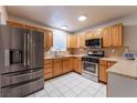 Spacious kitchen featuring stainless steel appliances, tile floors and light wood cabinets at 6608 Burgundy Way, Las Vegas, NV 89107