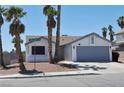 Inviting single-story home with desert landscaping, swaying palm trees, and a welcoming two-car garage at 6929 Montcliff Ave, Las Vegas, NV 89147