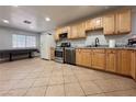 The kitchen features stainless steel appliances, granite countertops and tile flooring at 6929 Montcliff Ave, Las Vegas, NV 89147