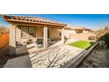 A covered patio with a grill and a small patch of artificial turf in backyard at 766 Topocoba St, Las Vegas, NV 89178
