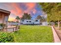 Spacious backyard with lush green grass, patio seating, and a convenient RV parking area at 7670 Descanso Ln, Las Vegas, NV 89123