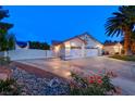 Wide driveway leading to a two-car garage, complemented by desert landscaping and a secure gate at 7670 Descanso Ln, Las Vegas, NV 89123