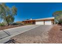 Attractive single-story home with a long driveway, a two-car garage, and appealing front yard landscaping at 7950 Red Barn Dr, Las Vegas, NV 89123