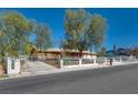 Charming property featuring mature trees, a gated fence, and a welcoming front exterior at 7950 Red Barn Dr, Las Vegas, NV 89123