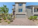 Modern two-story home with a stone facade, landscaped yard, balcony, and brick driveway at 7983 Texas Hills St, Las Vegas, NV 89113