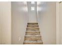 Carpeted stairs leading to the upper level with a small window for added light at 8717 Red Brook Dr # 201, Las Vegas, NV 89128