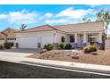 Single-story home boasts a two-car garage and a well-maintained front yard with desert landscaping at 8849 Pheasant Valley Way, Las Vegas, NV 89123