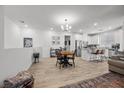 Open-concept living space with modern lighting, a kitchen island, stainless steel appliances, and wood-look flooring at 965 Nevada State Dr # 41201, Henderson, NV 89002