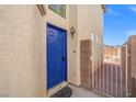 A vibrant blue front door adds a pop of color to this home's exterior, inviting you inside at 10642 Dawns Mist Ave, Las Vegas, NV 89129