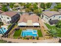Aerial view of a backyard with a sparkling pool, spa, covered patio, and lush landscaping at 1387 Minuet St, Henderson, NV 89052