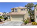 Front view of a two-story home with a terracotta roof, two-car garage, and desert landscaping at 1833 Winners Cup Dr, Las Vegas, NV 89117
