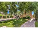 Landscaped front yard with mature trees and brick walkway leading to the home's entrance at 27 Via Paradiso St, Henderson, NV 89011