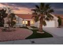 Inviting single-story home featuring lush landscape, desert rock and a two-car garage at 2816 Golfside Dr, Las Vegas, NV 89134