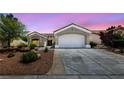 Inviting single-story home boasts a well-kept front yard with desert landscaping, an attached two-car garage, and neutral tones at 2816 High Range Dr, Las Vegas, NV 89134