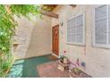 Close up of front door, welcome mat, wooden door and sidelight, plants and muted paint at 3158 La Luna Cir, Henderson, NV 89014