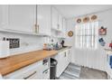 Bright kitchen featuring white cabinetry, wood countertops, and stainless steel sink at 3158 La Luna Cir, Henderson, NV 89014