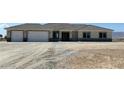 Single story home with a gray exterior, a three car garage, and desert landscaping at 3791 Soplo Rd, Pahrump, NV 89048