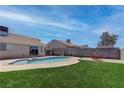 Inviting backyard featuring a sparkling pool, lush lawn, and a brick privacy wall at 394 Lombardy Cir, Henderson, NV 89015