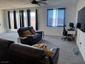 Spacious living room featuring plush carpeting, modern ceiling fan, and lots of room to relax at 411 Hellebores Ave, North Las Vegas, NV 89084