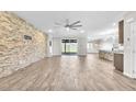 Open living area with modern finishes, including a stone accent wall, wood-look floors, and sliding glass doors at 4510 Rubious Ave, North Las Vegas, NV 89084