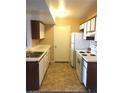 Efficient kitchen design with white cabinets, essential appliances, and tiled floor at 5220 Mission Carmel Ln # 207, Las Vegas, NV 89107