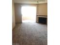 Spacious living room with plush carpeting, fireplace, and bright patio doors at 5220 Mission Carmel Ln # 207, Las Vegas, NV 89107