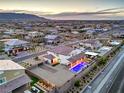 Expansive aerial view of a modern desert home with a pool, patio, and mountain views at dusk at 5328 Hickory Tree St, Las Vegas, NV 89149