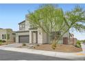 This two-story residence features stone accents, xeriscaping and a well-manicured tree at 6830 Fallen Rock St, North Las Vegas, NV 89084