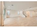 An open living space with large sliding glass doors, neutral tile flooring and a staircase to the second floor at 6830 Fallen Rock St, North Las Vegas, NV 89084