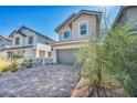 Two-story home with a charming brick driveway, a two car garage and mature landscaping in the front yard at 688 Monroe Hill Pl, Henderson, NV 89011