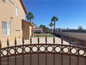 View of backyard featuring desert landscaping, putting green, and wrought iron gates at 7020 King Solomons Ct, Las Vegas, NV 89117