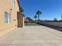 View of backyard featuring desert landscaping, putting green, and concrete patio at 7020 King Solomons Ct, Las Vegas, NV 89117