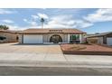 Single-story home with desert landscaping, arched entryway, and two-car garage on a sunny day at 706 Greenway Rd, Henderson, NV 89002