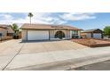 Exterior view of a one story home with desert landscaping, arched entryway, and two-car garage at 706 Greenway Rd, Henderson, NV 89002