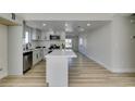 Spacious kitchen with stainless steel appliances, white cabinets and a center island open to a large dining area at 706 Greenway Rd, Henderson, NV 89002