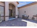 Charming front patio featuring brick pavers, seating area and a welcoming entrance to the home at 7228 Fern Meadow St, Las Vegas, NV 89149