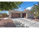 Spacious three-car garage with dark wood doors and desert landscaping at 7289 Sea Anchor Ct, Las Vegas, NV 89131