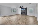 A spacious living room with modern fireplace, fan, wood-look flooring, and natural light at 8043 Tank Loop St, Las Vegas, NV 89166