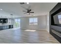 Bright and airy living room with wood flooring, sliding glass doors, and a modern fireplace feature at 8108 Artistic Heights Ct, Las Vegas, NV 89143