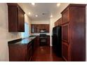 Modern kitchen boasts stainless steel appliances, dark wood cabinets, and black granite countertops at 8218 Golden Flowers St, Las Vegas, NV 89139