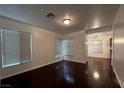 Open living room with dark wood floors, lots of natural light from large windows, and recessed lighting at 8218 Golden Flowers St, Las Vegas, NV 89139