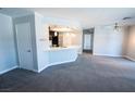 Open-concept living room with carpeted floors flowing into a kitchen area with modern lighting at 8600 W Charleston Blvd # 2068, Las Vegas, NV 89117