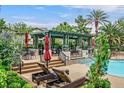 Beautiful community pool area with lounge chairs, lush landscaping, and covered seating at 8737 Red Brook Dr # 201, Las Vegas, NV 89128