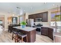 Bright kitchen features an island with seating, stainless steel appliances, and an open layout to the dining area at 8934 Libertyvale Dr, Las Vegas, NV 89123