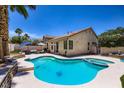 Backyard boasts a sparkling pool and spa surrounded by a patio area, ideal for outdoor entertaining and relaxation at 8934 Libertyvale Dr, Las Vegas, NV 89123