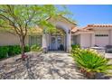Inviting front entrance with a charming archway, double doors, and lush landscaping at 905 White Thunder St, Henderson, NV 89002