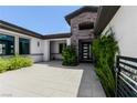 Charming front entrance with stone accents, a black front door, and lush greenery at 9475 W Rosada Way, Las Vegas, NV 89149